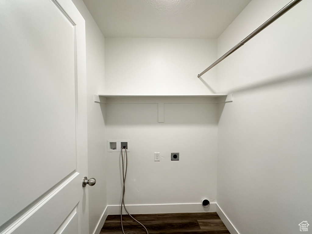 Washroom with electric dryer hookup, washer hookup, dark wood-style flooring, and baseboards