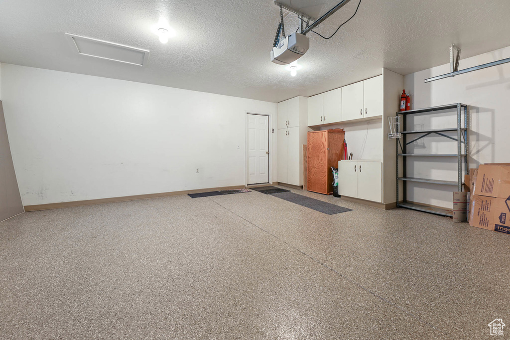 Garage with a garage door opener and baseboards