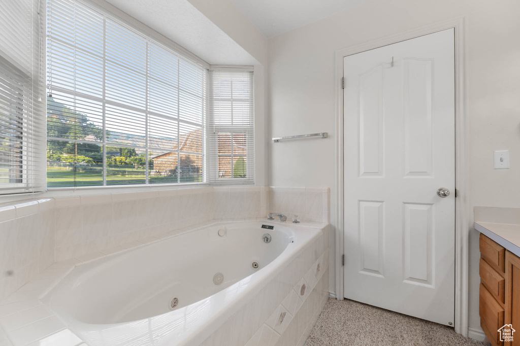 Full bathroom featuring vanity, a whirlpool tub, and speckled floor