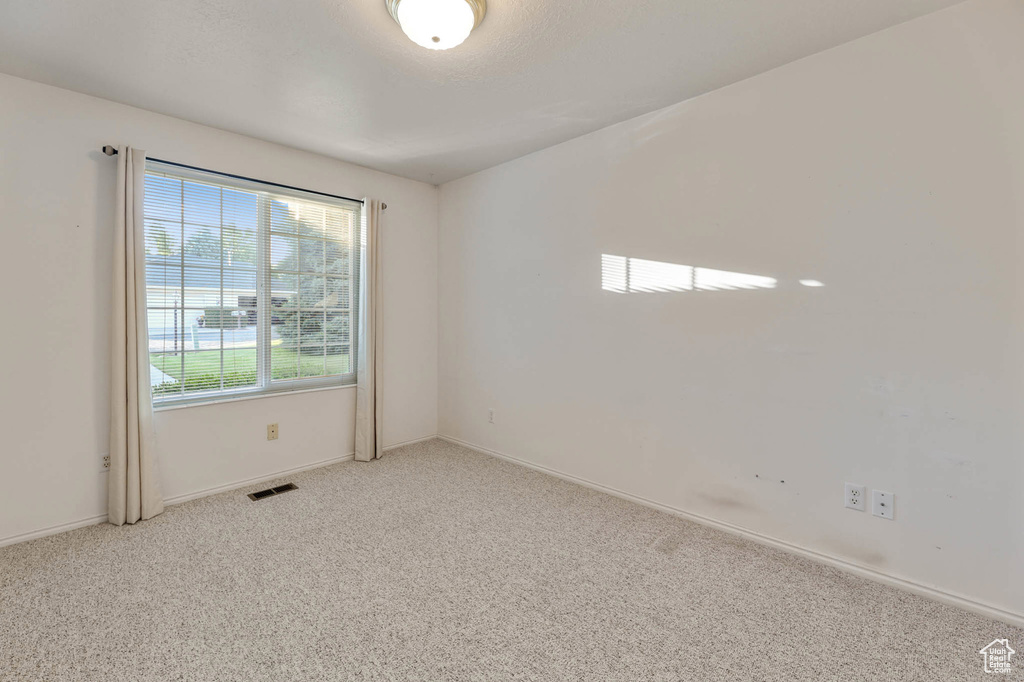 Empty room featuring carpet floors and baseboards