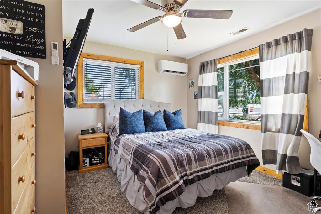 Bedroom with carpet, a wall unit AC, and ceiling fan