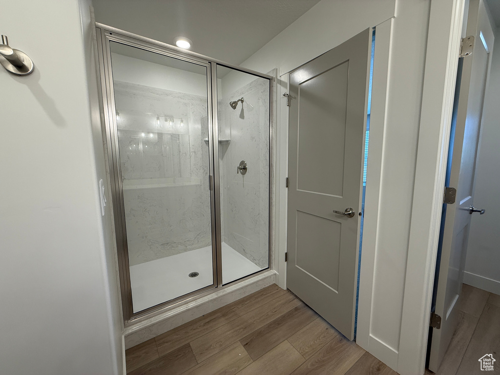 Bathroom featuring a shower stall and wood finished floors