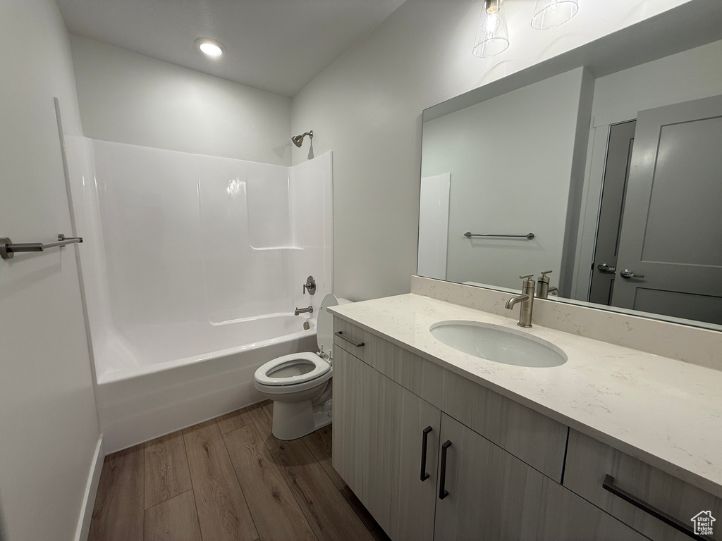 Full bathroom with wood finished floors, vanity, toilet, and shower / bathtub combination