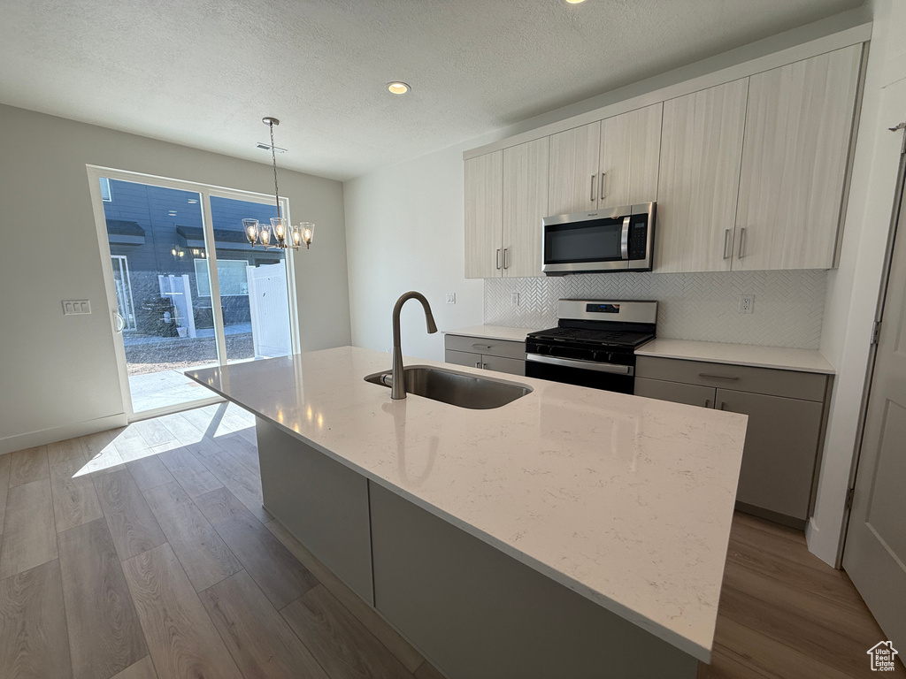 Kitchen featuring appliances with stainless steel finishes, a sink, tasteful backsplash, dark wood-style floors, and recessed lighting