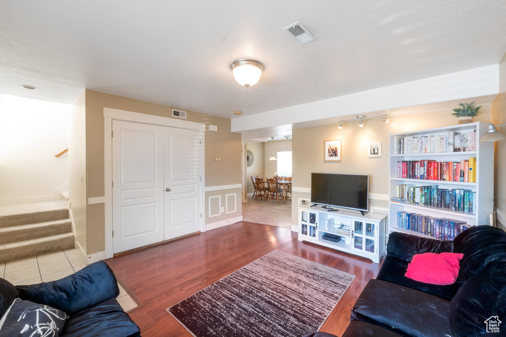 Living room featuring stairway, wood finished floors, and wainscoting