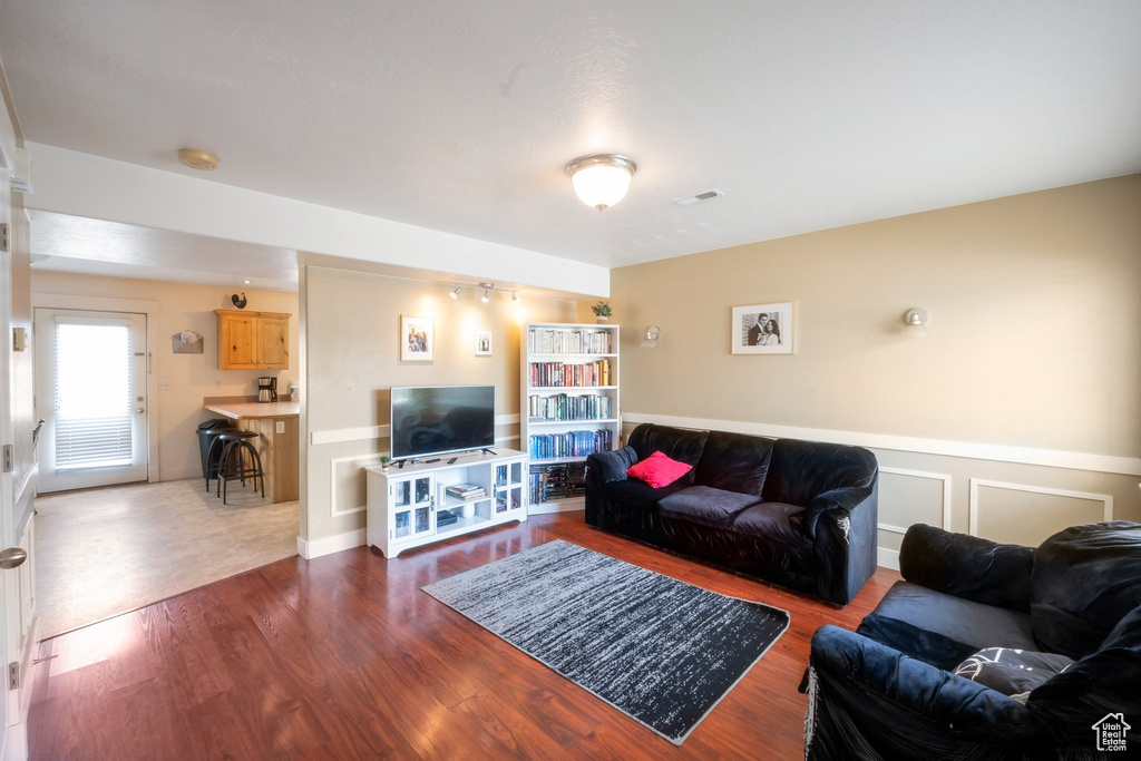 Living area with wood finished floors and a wainscoted wall