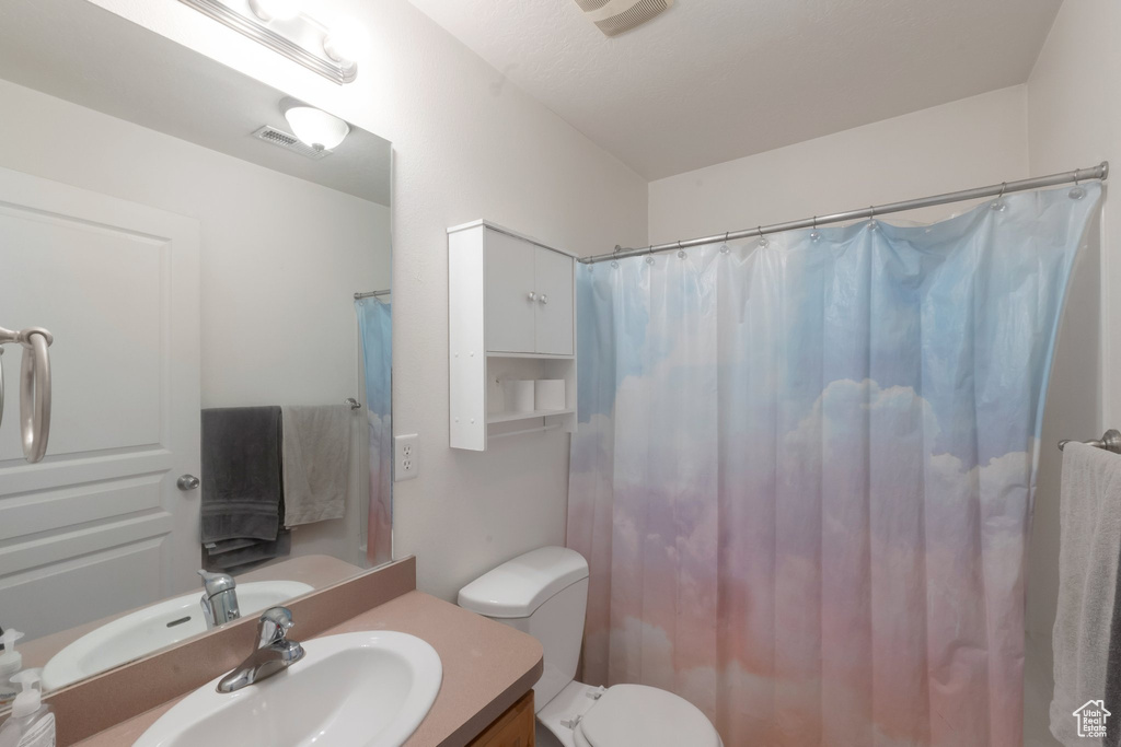 Full bathroom with vanity, toilet, and a shower with curtain