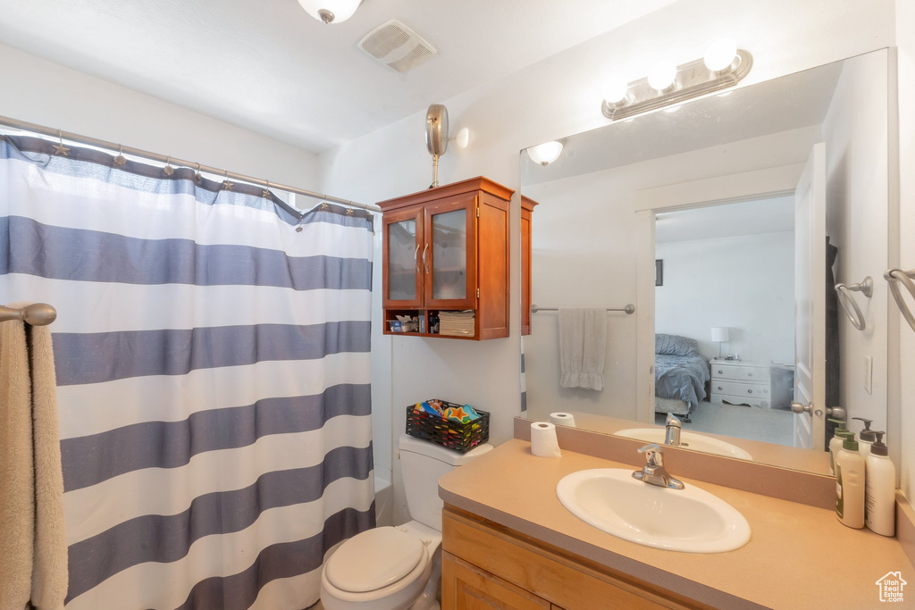 Ensuite bathroom featuring vanity, toilet, and a shower with shower curtain