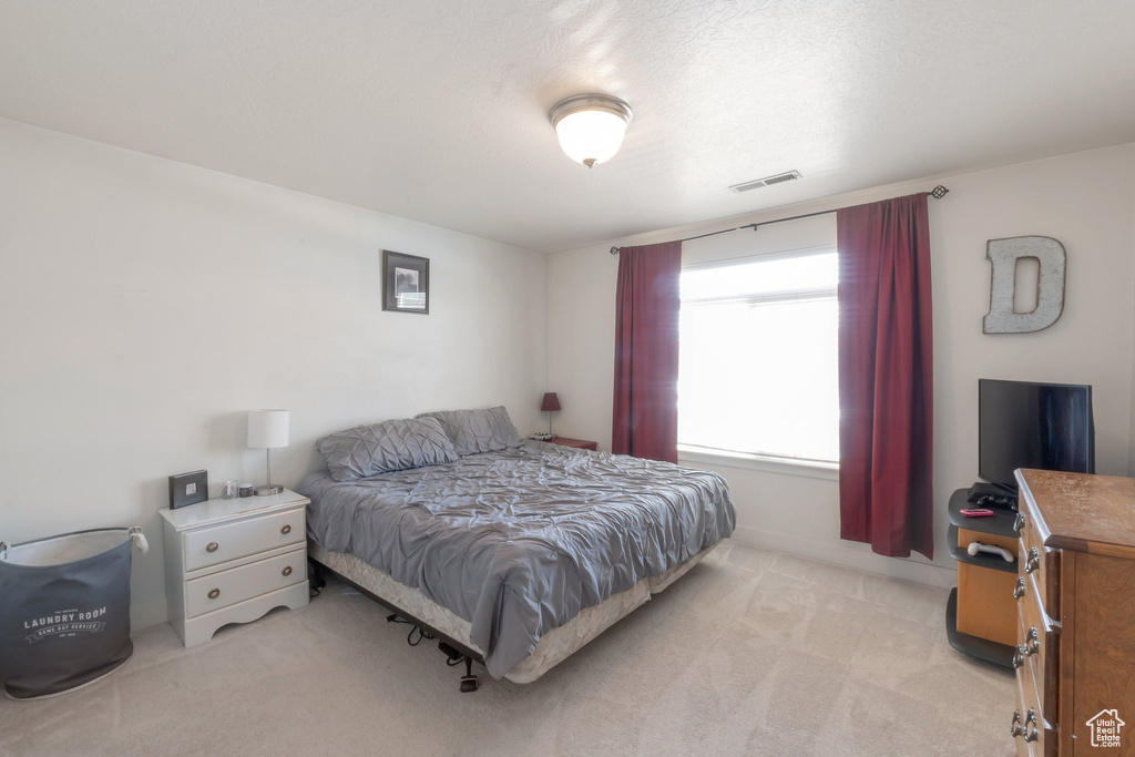 Bedroom featuring light carpet