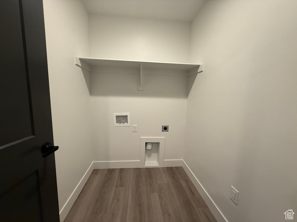 Washroom featuring dark wood-style flooring, electric dryer hookup, washer hookup, and baseboards