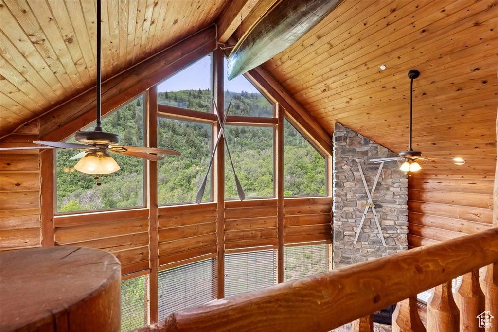 Detailed view of ceiling fan, log walls, and wooden ceiling with exposed beams