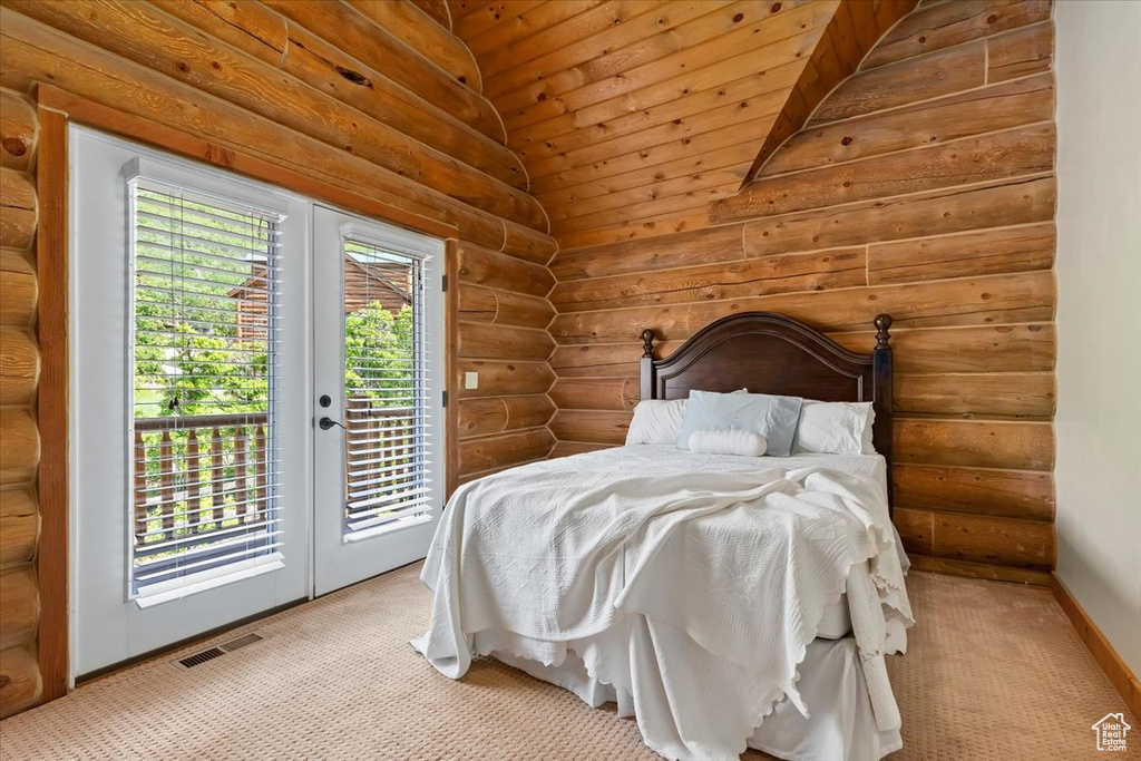 Bedroom featuring rustic walls, access to exterior, french doors, carpet, and baseboards