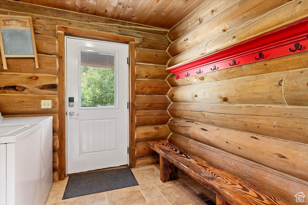 Mudroom featuring independent washer and dryer, log walls, and wood ceiling