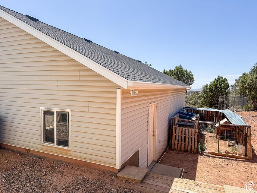 View of side of home featuring roof with shingles