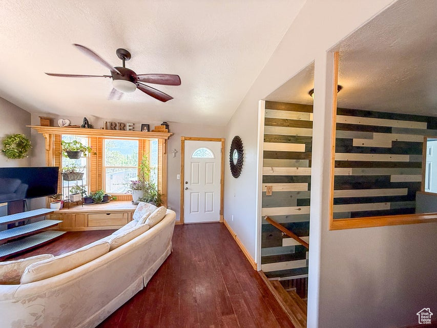 Foyer entrance featuring a ceiling fan, wood finished floors, a textured ceiling, and baseboards