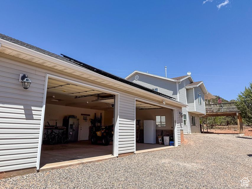 View of property exterior featuring a garage and gravel driveway