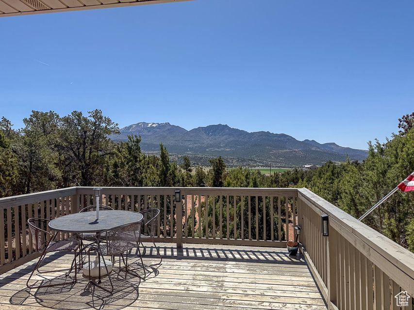 Wooden deck with a mountain view and outdoor dining space
