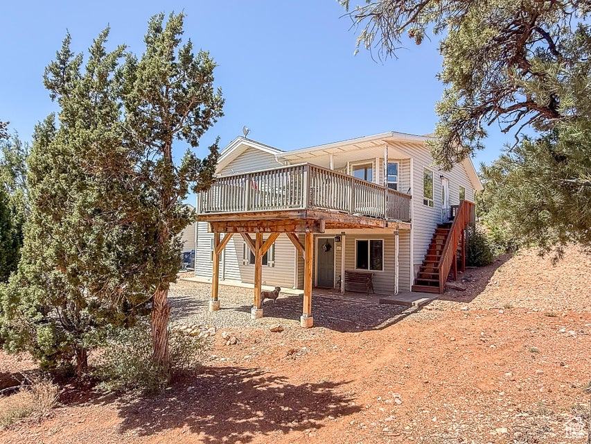 Back of property featuring a wooden deck and stairs