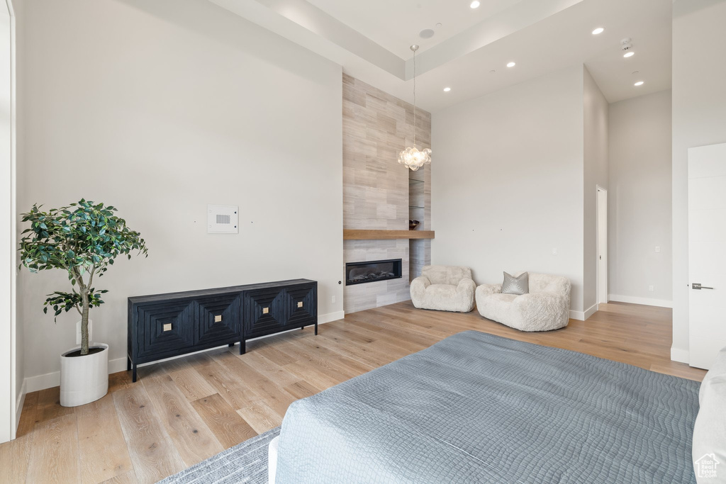 Bedroom featuring wood finished floors, a large fireplace, recessed lighting, and baseboards