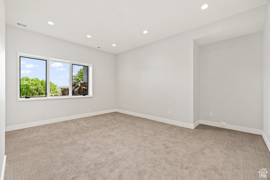 Empty room featuring recessed lighting, carpet, and baseboards