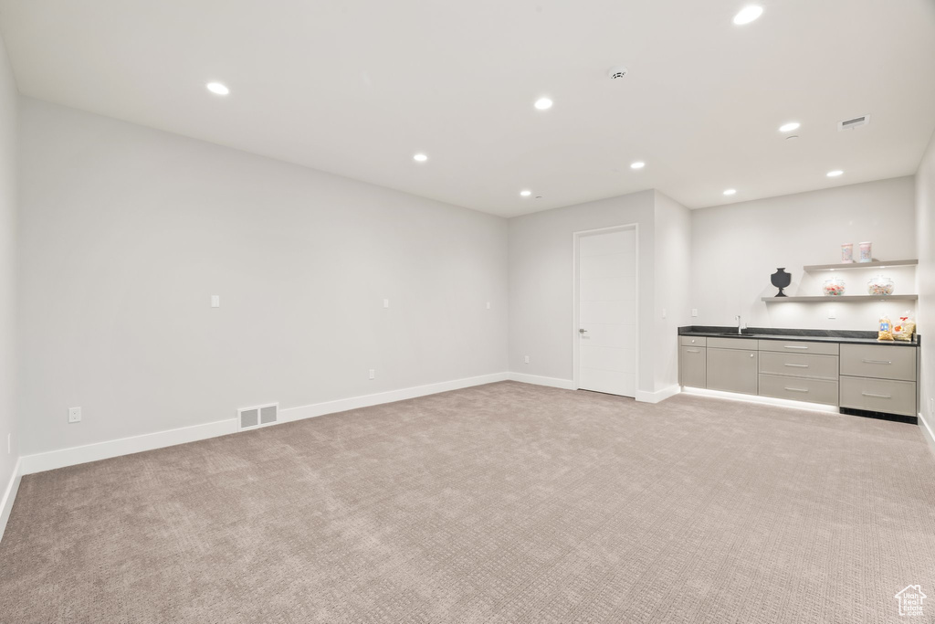 Indoor wet bar with light carpet, recessed lighting, and baseboards