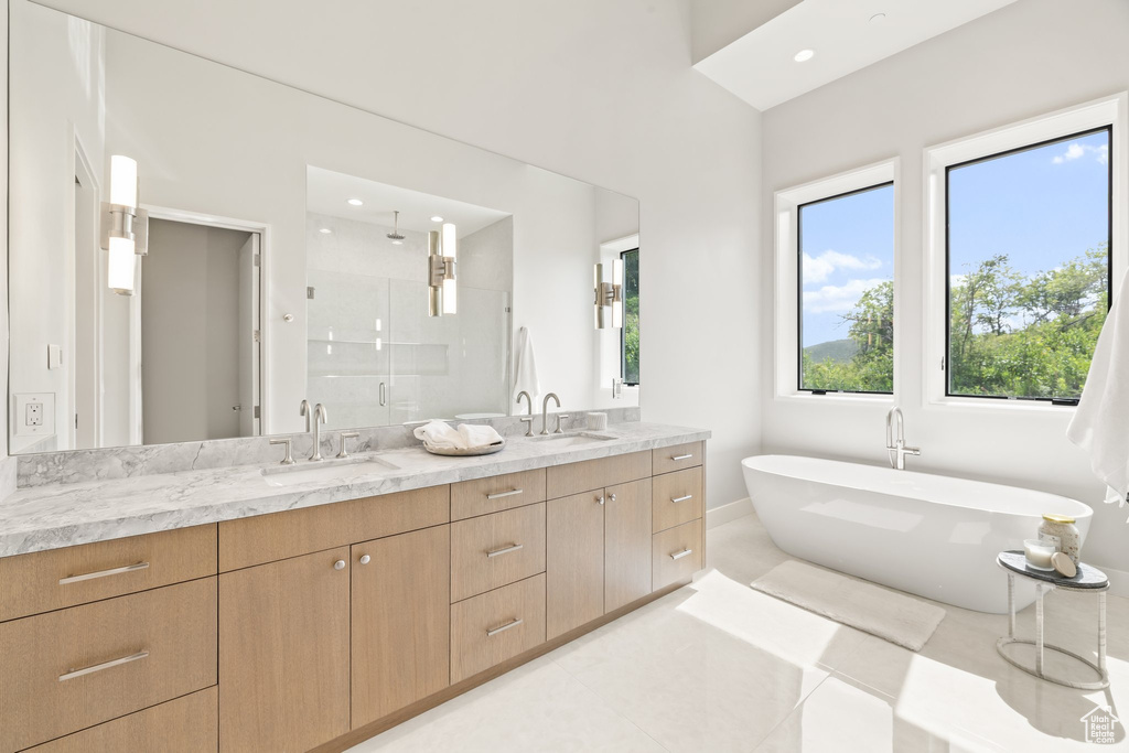 Bathroom with a shower stall, double vanity, a freestanding bath, tile patterned floors, and recessed lighting