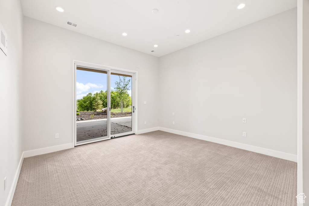 Carpeted spare room with baseboards and recessed lighting