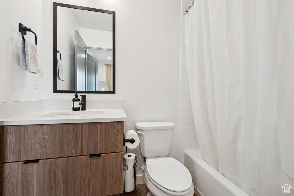 Full bathroom featuring vanity, toilet, and shower / tub combo with curtain