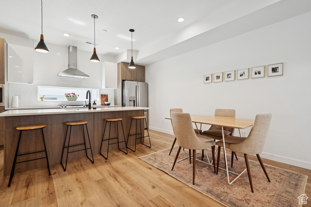 Dining space featuring light wood-style flooring, recessed lighting, and baseboards