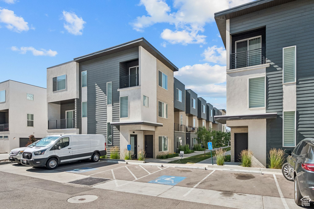 View of building exterior with uncovered parking and a residential view