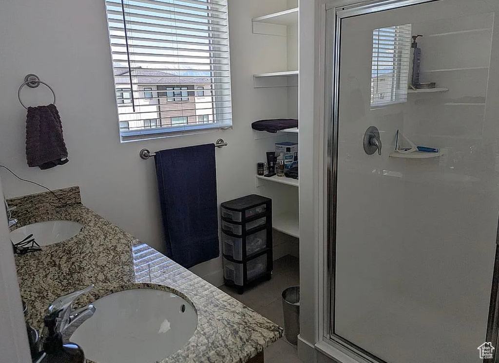 Bathroom with a shower stall, plenty of natural light, and double vanity