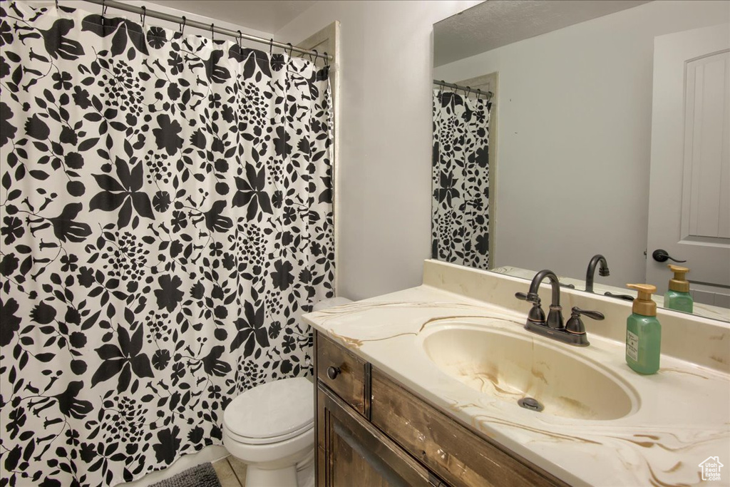 Full bath with vanity, toilet, and a shower with curtain