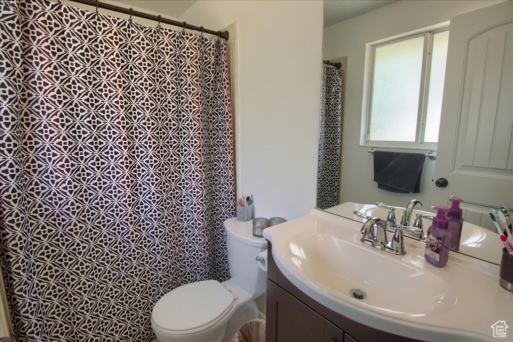 Full bathroom featuring vanity, toilet, and a shower with curtain