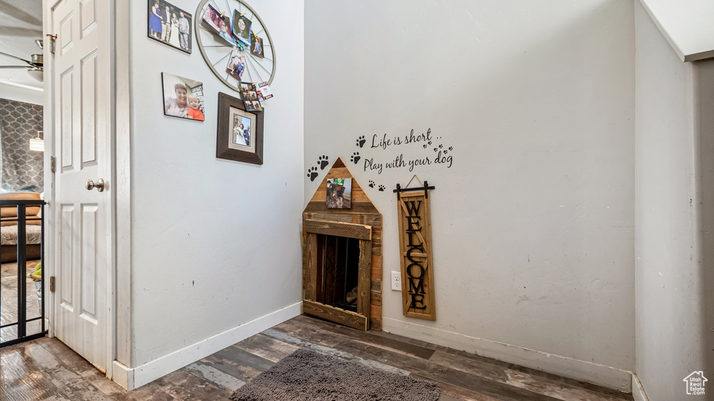 Detailed view of wood finished floors, ceiling fan, and baseboards