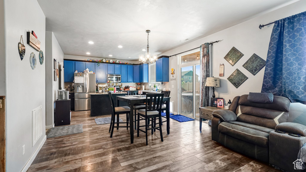 Dining area featuring a chandelier, dark wood-style flooring, and recessed lighting