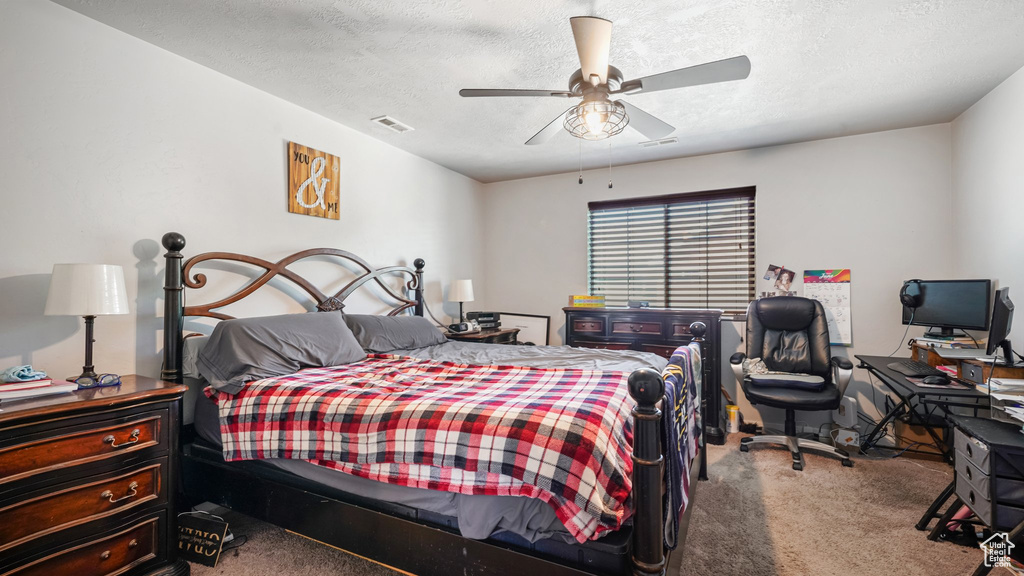 Bedroom featuring carpet floors, a textured ceiling, and ceiling fan