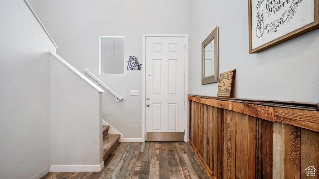 Entryway with stairway, wood finished floors, and baseboards