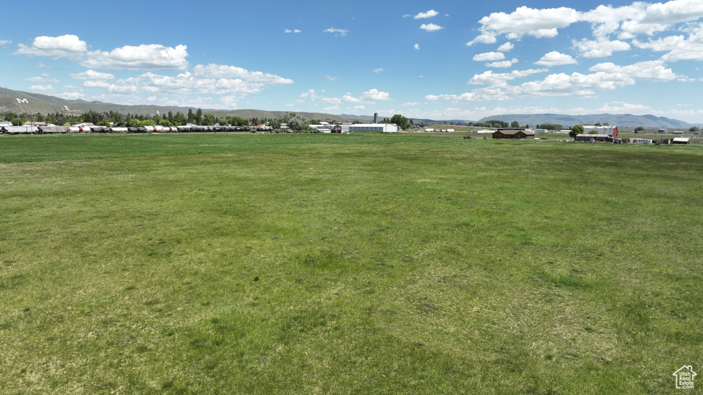View of property's community featuring a mountain view, a view of countryside, and a yard
