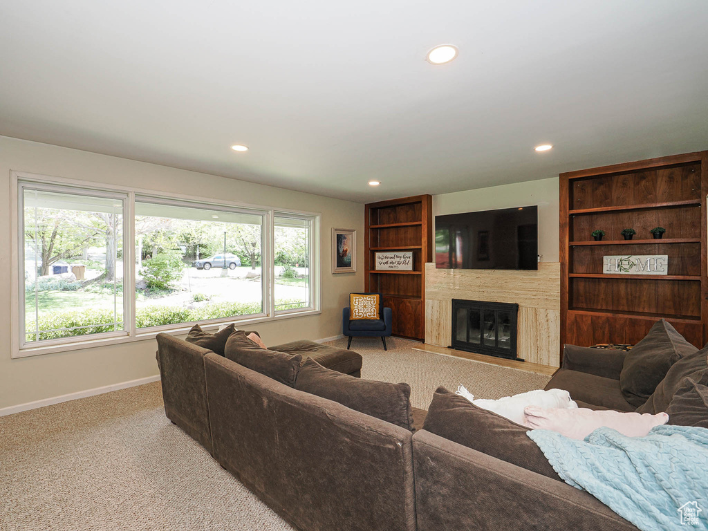 Living area featuring baseboards, a large fireplace, recessed lighting, and light colored carpet