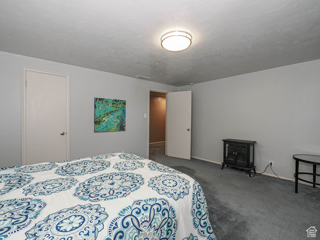 Bedroom with a wood stove and carpet