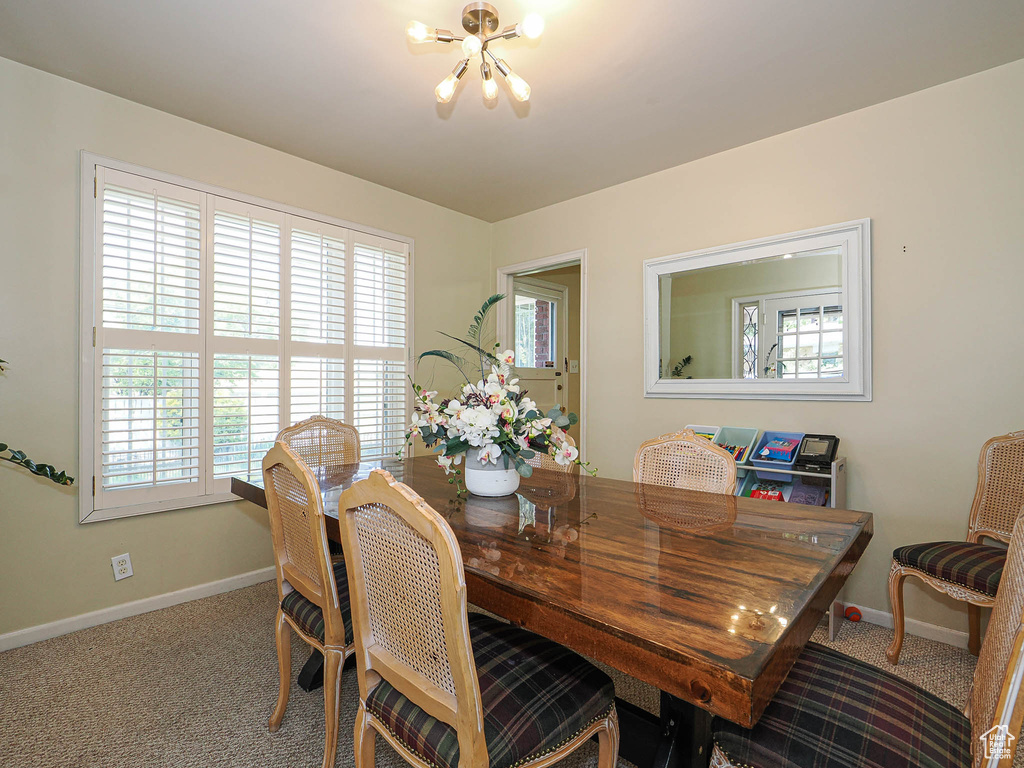 Dining space featuring a chandelier, baseboards, and carpet floors