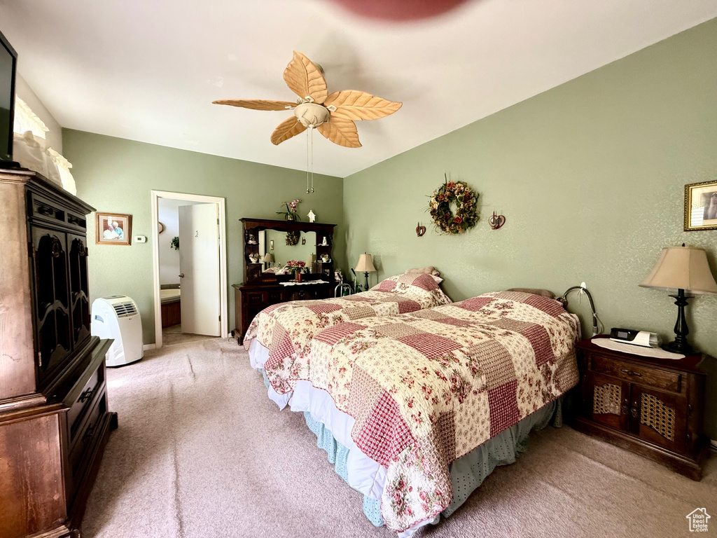 Carpeted bedroom featuring ceiling fan