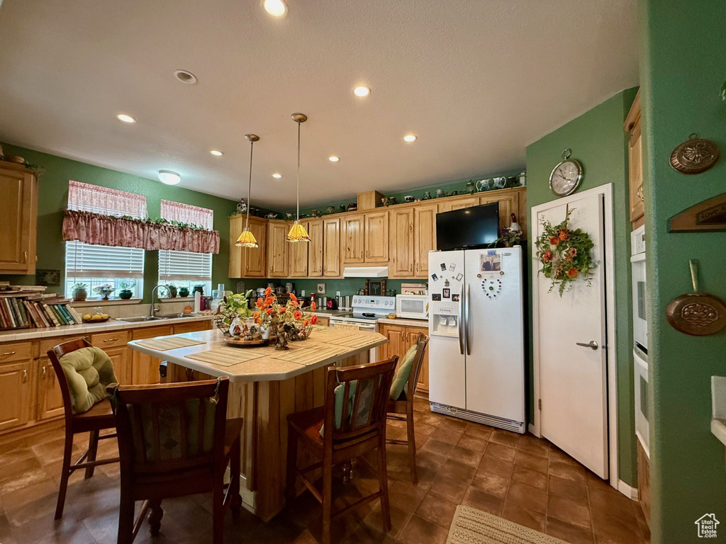 Kitchen featuring white appliances, tile countertops, a sink, a center island, and recessed lighting