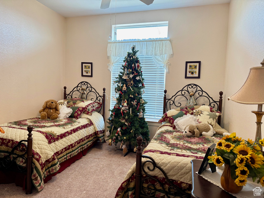 Carpeted bedroom featuring a ceiling fan