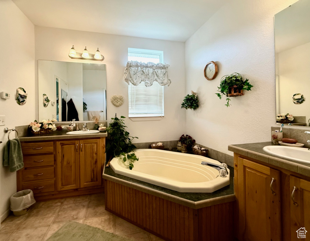 Full bathroom with two vanities, a garden tub, and tile patterned flooring