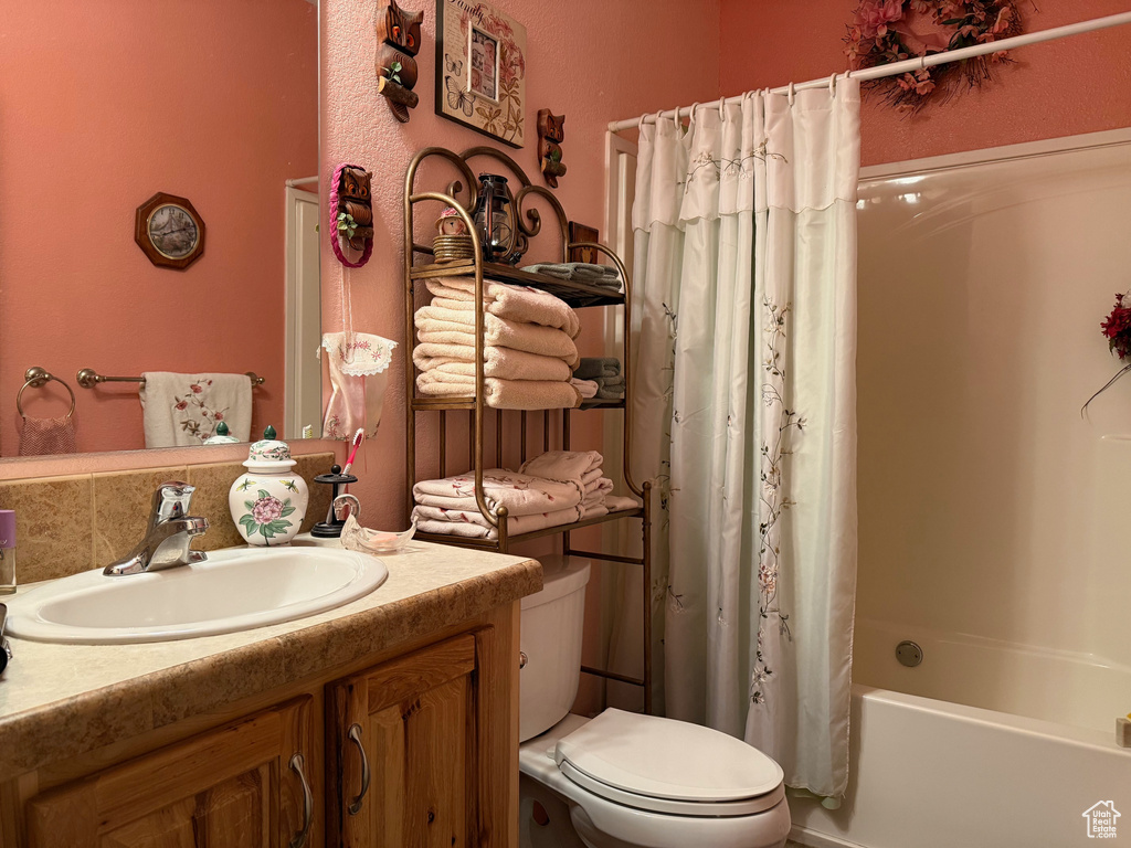 Bathroom featuring vanity, toilet, and shower / tub combo with curtain