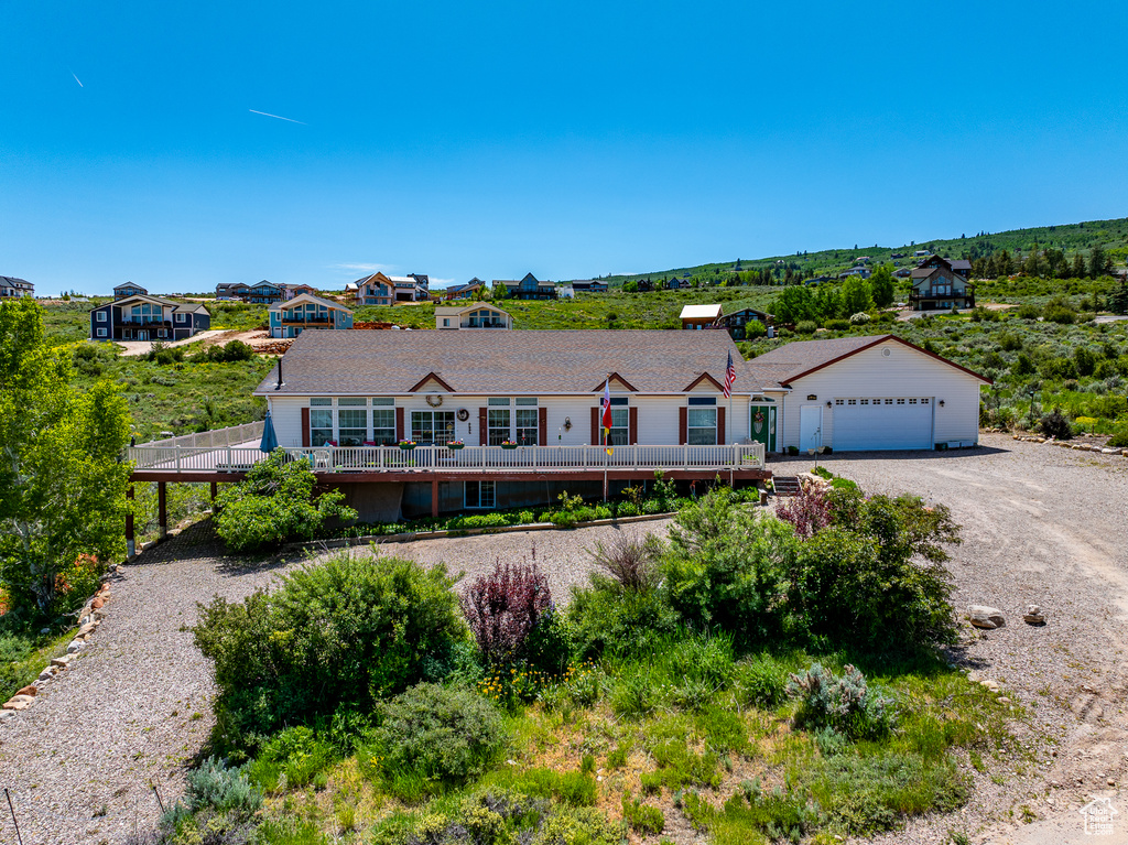 Ranch-style house featuring gravel driveway and a wooden deck