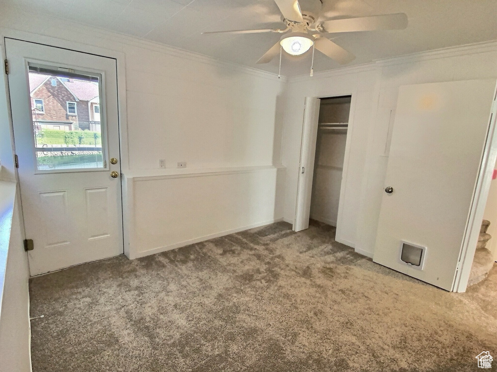 Unfurnished bedroom with carpet flooring, ornamental molding, a closet, and ceiling fan