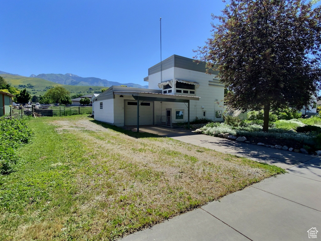 Back of house with a mountain view and concrete driveway