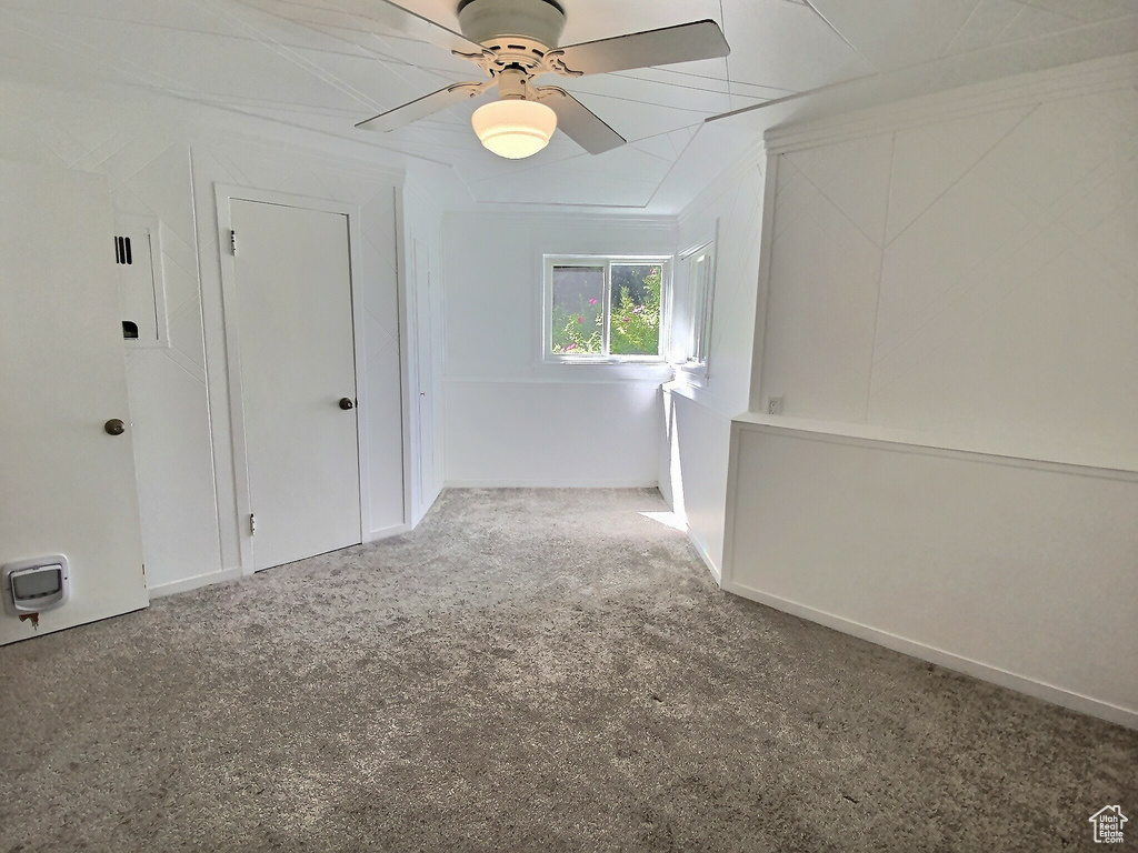 Empty room featuring carpet floors and ceiling fan